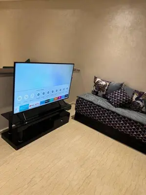 a living room with a flat screen tv and a couch at Nice appartement In Rabat-Temara in Temara