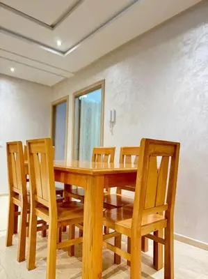 a dining room with a wooden table and chairs at Nice appartement In Rabat-Temara in Temara