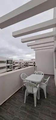 a patio with a table and chairs on a balcony at Bel Appartement neuf à 7 min de la plage avec piscine privée in Mohammedia
