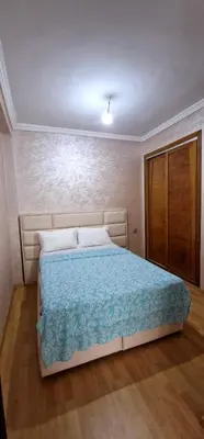 a bedroom with a bed with a blue comforter at Bel Appartement neuf à 7 min de la plage avec piscine privée in Mohammedia
