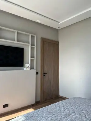 a bedroom with a bed and a television and a door at Modern Ocean View Apartment in Casablanca