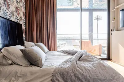 a bed in a bedroom with a large window at Modern Ocean View Apartment in Casablanca