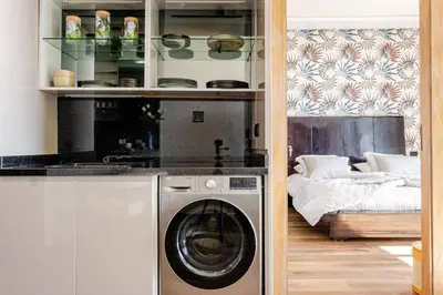a kitchen with a washing machine next to a bed at Modern Ocean View Apartment in Casablanca