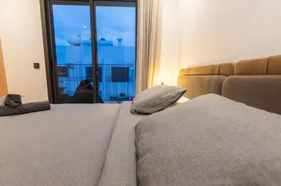 a bedroom with a bed and a couch and a window at So Chic & Lumineux Appartement Avec Terrasse Ensoleillée Au Coeur De Maarif Quartier Palmier Avec Parking Prés de Tramway Et Restaurants Luigi Casablanca in Casablanca