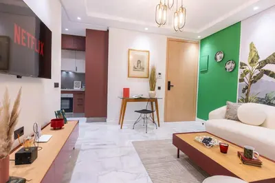 a living room with a couch and a table at So Chic & Lumineux Appartement Avec Terrasse Ensoleillée Au Coeur De Maarif Quartier Palmier Avec Parking Prés de Tramway Et Restaurants Luigi Casablanca in Casablanca
