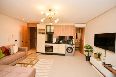 a living room with a couch and a kitchen at Studio 07 Maarif - High Speed Wi-Fi in Casablanca
