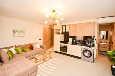 a living room with a couch and a kitchen at Studio 07 Maarif - High Speed Wi-Fi in Casablanca