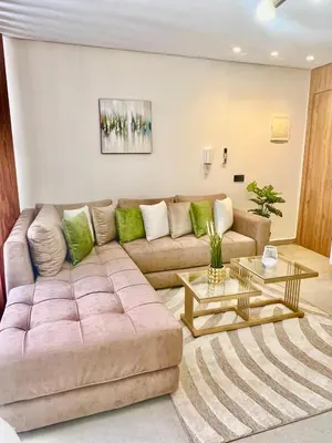 a living room with a large couch and two tables at Studio 07 Maarif - High Speed Wi-Fi in Casablanca