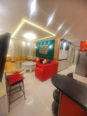 a living room with a red couch and a table at Grand et magnifique appartement in Casablanca