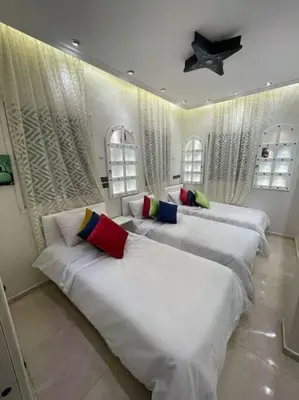 three beds in a room with white sheets and pillows at Spacieux appartement corniche in Casablanca