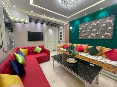 a living room with a red couch with colorful pillows at Spacieux appartement corniche in Casablanca