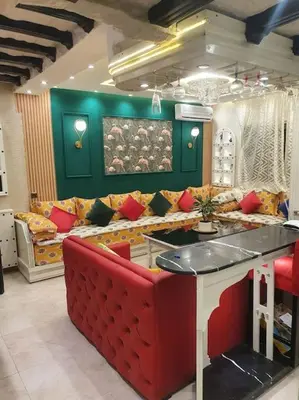 a living room with a couch and a red couch at Spacieux appartement corniche in Casablanca
