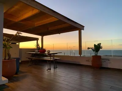 a patio with a table and a view of the ocean at The Atlantica Ocean view apartment in Dar Bouazza