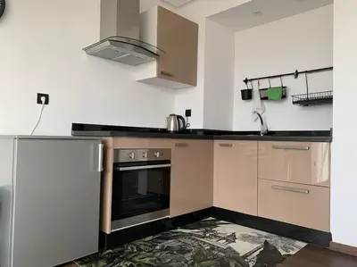 a kitchen with a stove and a refrigerator at The Atlantica Ocean view apartment in Dar Bouazza