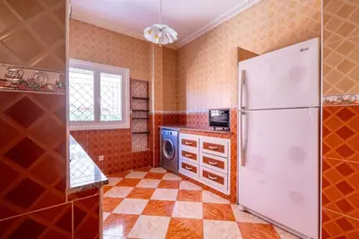 a kitchen with a white refrigerator and a tile floor at Appartement Cosy et Confortable in Casablanca