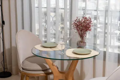 a glass table with two chairs and a vase with flowers at Gauthier Luxe , 1BR Apart- Comfort & Style in Casa in Casablanca