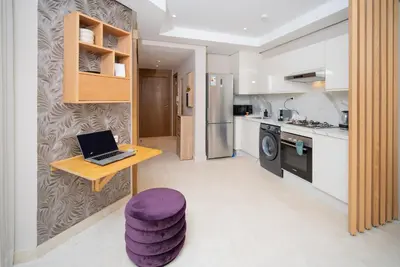 a kitchen with a laptop on a table with a purple stool at Gauthier Luxe , 1BR Apart- Comfort & Style in Casa in Casablanca