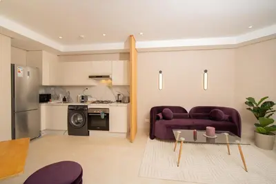 a living room with a purple couch and a kitchen at Gauthier Luxe , 1BR Apart- Comfort & Style in Casa in Casablanca