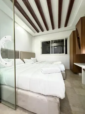 a bedroom with two large beds and a window at SUITOUISS - Agdal 3 - Appartement à 2 minutes de la gare de train TGV Rabat in Rabat