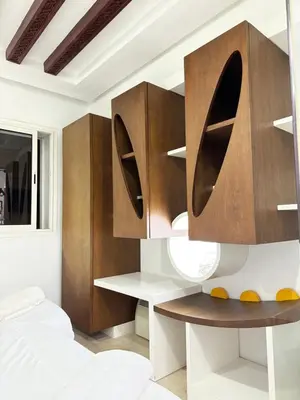 a bedroom with a bed and wooden cabinets at SUITOUISS - Agdal 3 - Appartement à 2 minutes de la gare de train TGV Rabat in Rabat