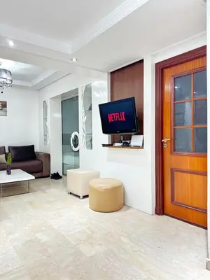 a living room with a tv on a wall at SUITOUISS - Agdal 3 - Appartement à 2 minutes de la gare de train TGV Rabat in Rabat