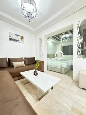 a living room with a couch and a table at SUITOUISS - Agdal 3 - Appartement à 2 minutes de la gare de train TGV Rabat in Rabat
