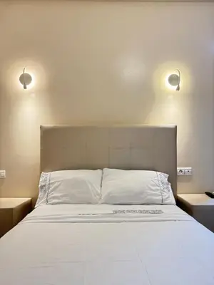 a bedroom with a large bed with two lights above it at SUITOUISS - Agdal 3 - Appartement à 2 minutes de la gare de train TGV Rabat in Rabat