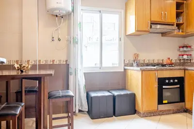 a kitchen with a table and a window and a table and stool at Appartement avec terrasse en plein centre de ville in Casablanca