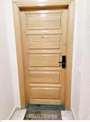a wooden door with a sign in front of it at Appartement avec terrasse en plein centre de ville in Casablanca