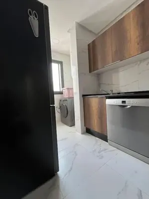 a kitchen with a black door and a sink at Appartement Les pieds dans l'eau in Oulad Kerroum