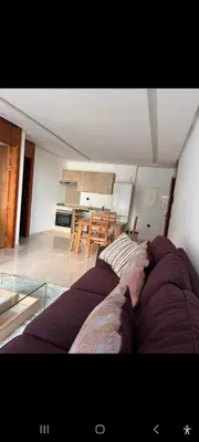 a living room with a bed and a kitchen at Cosy studio avec grande terasse et parking CFC in Casablanca