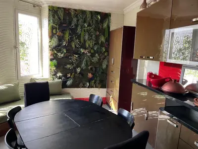a kitchen with a table and a wall with plants at Appartement Emil zola BELVÉDÈRE in Casablanca