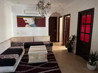 a living room with a couch and a painting on the wall at Appartement Emil zola BELVÉDÈRE in Casablanca