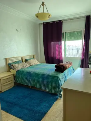 a bedroom with a bed and a blue rug at Appartement Emil zola BELVÉDÈRE in Casablanca