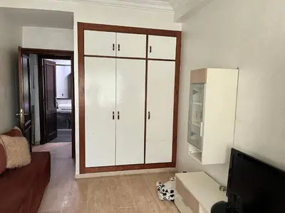 a living room with white cabinets and a tv at Appartement Emil zola BELVÉDÈRE in Casablanca