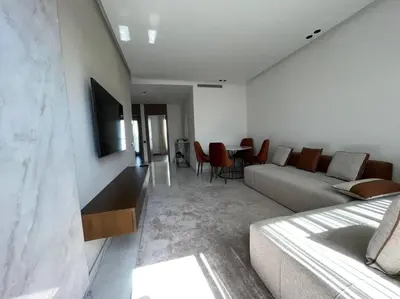 a living room with a couch and a table at Appartement vaste et lumineux, Oasis in Casablanca