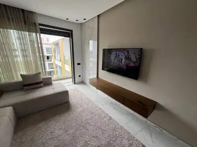 a living room with a couch and a large window at Appartement vaste et lumineux, Oasis in Casablanca