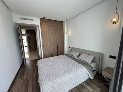 a bedroom with a bed and a wooden floor at Appartement vaste et lumineux, Oasis in Casablanca