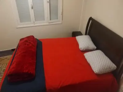 a bedroom with a red bed with two pillows at Sense housse in Rabat