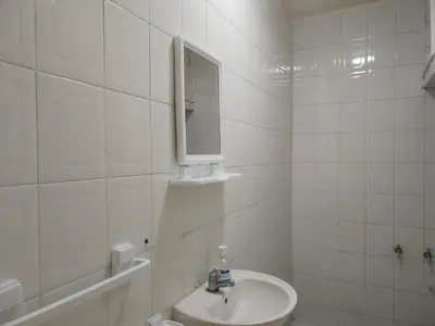 a white bathroom with a sink and a mirror at Sense housse in Rabat