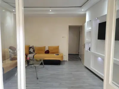 a living room with a yellow couch and a tv at Sense housse in Rabat