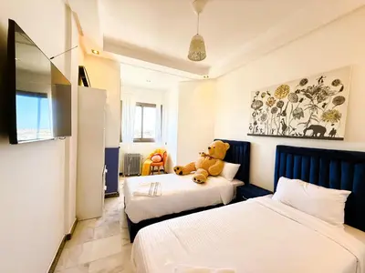 a teddy bear sitting on a bed in a bedroom at Cosy sunny central - 2 BDR near train and tram in Casablanca