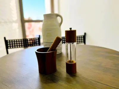 two cups on a wooden table with a bottle at Cosy sunny central - 2 BDR near train and tram in Casablanca