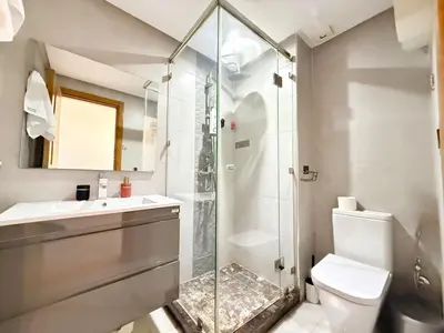 a bathroom with a shower and a sink and a toilet at Cosy sunny central - 2 BDR near train and tram in Casablanca