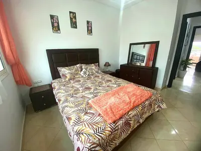 a bedroom with a bed with a comforter and a mirror at Salam Beach, El Mansouria in Pont Blondin