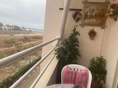 a balcony with a chair and a picture on the wall at Salam Beach, El Mansouria in Pont Blondin