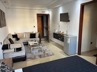 a living room with a couch and a refrigerator at Golden studio in Rabat