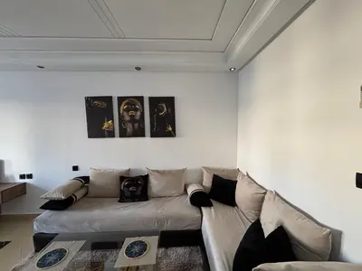 a living room with a couch and posters on the wall at Golden studio in Rabat