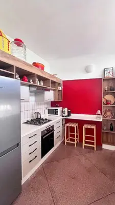 a kitchen with white counters and a red wall at Cosy vintage appartement with terrace in Rabat