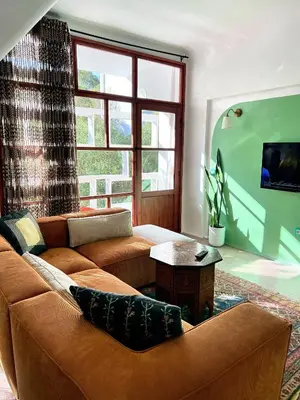 a living room with a couch and a table at Cosy vintage appartement with terrace in Rabat